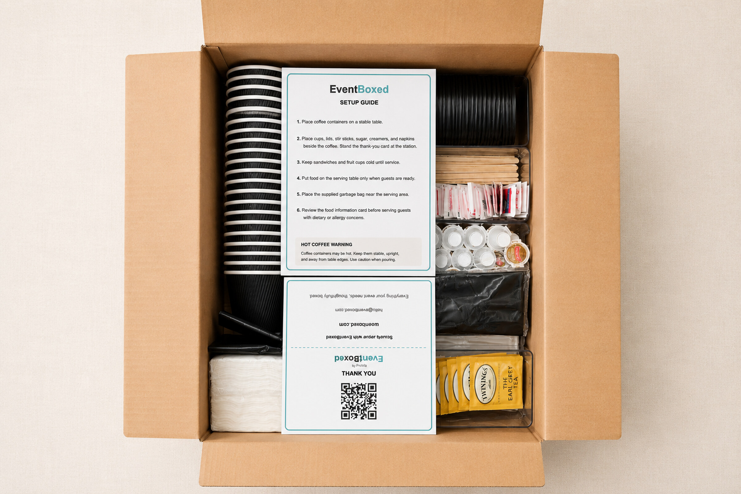 Open EventBoxed supplies box showing cups, lids, condiments, and setup materials